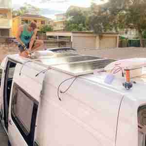 Man on roof installing Solar Panel for Campervan