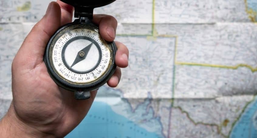 Man with compass in hand and a map in the background