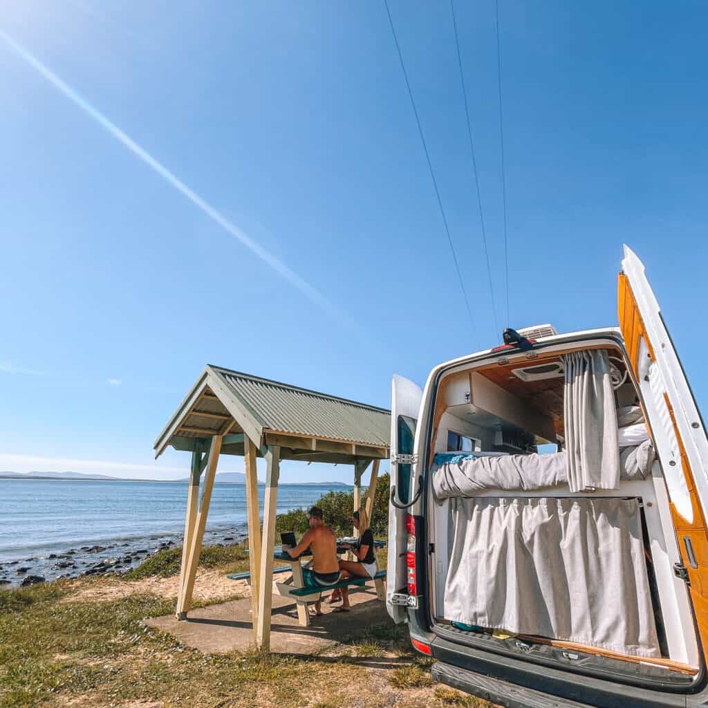 Camper van and man working at a beach