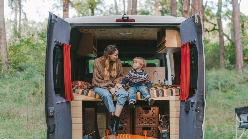 A lady and a boy seating inside a camper van 