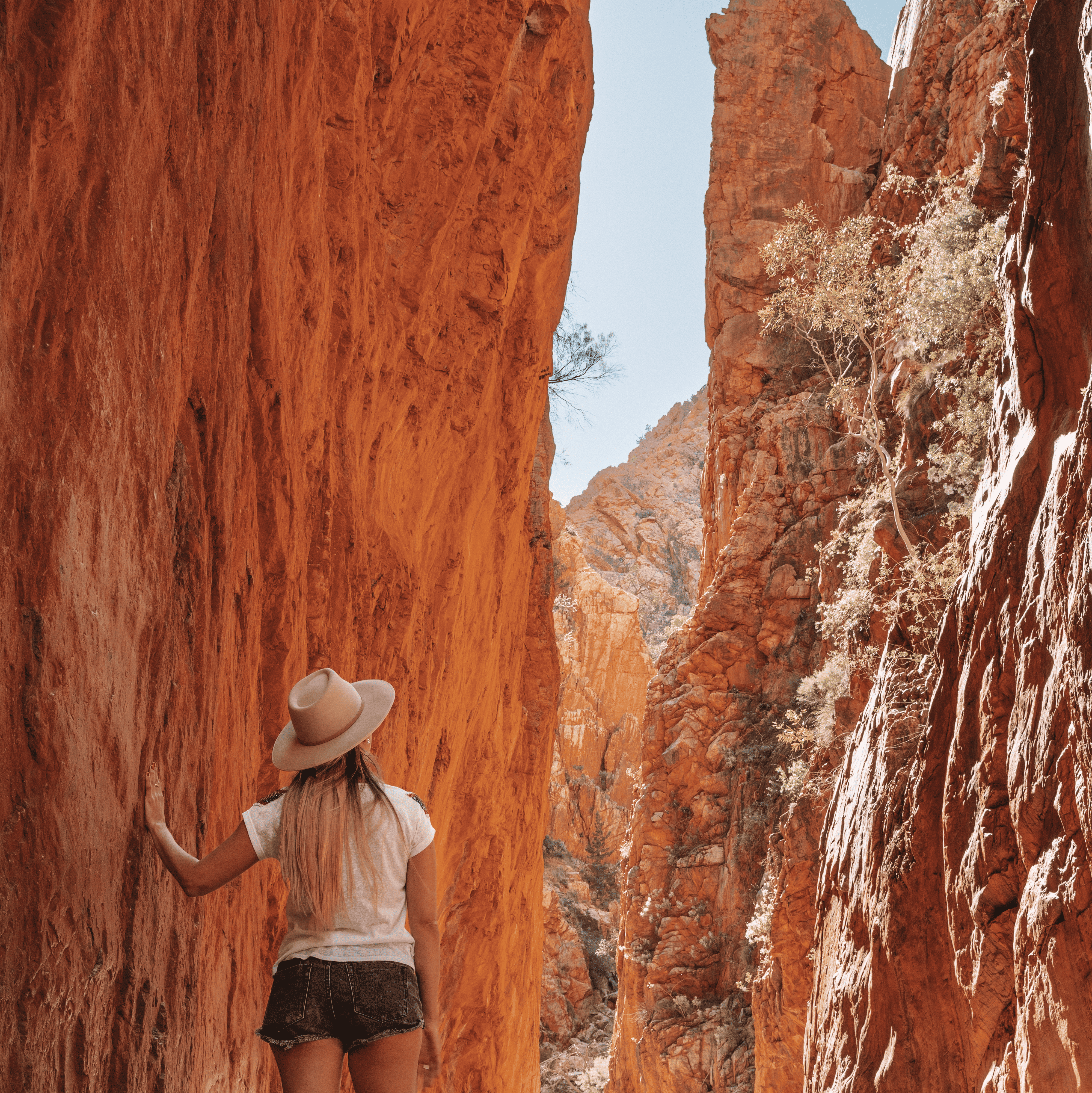 Dani at Standley Chasm - two massive blocks of rock with an opening in the middle where Dani is standing. 