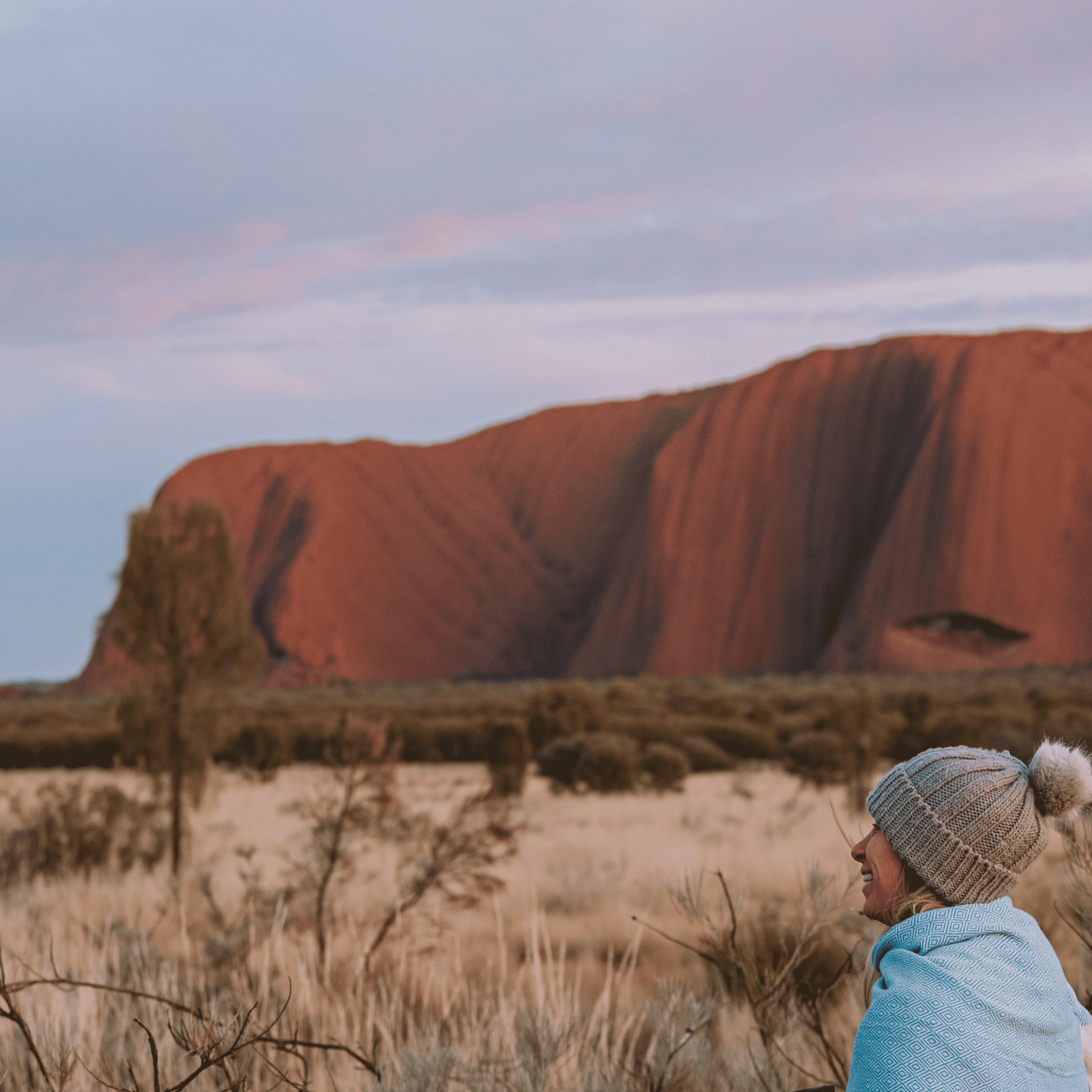 Dani smilling looking at Uluru during a sunrise