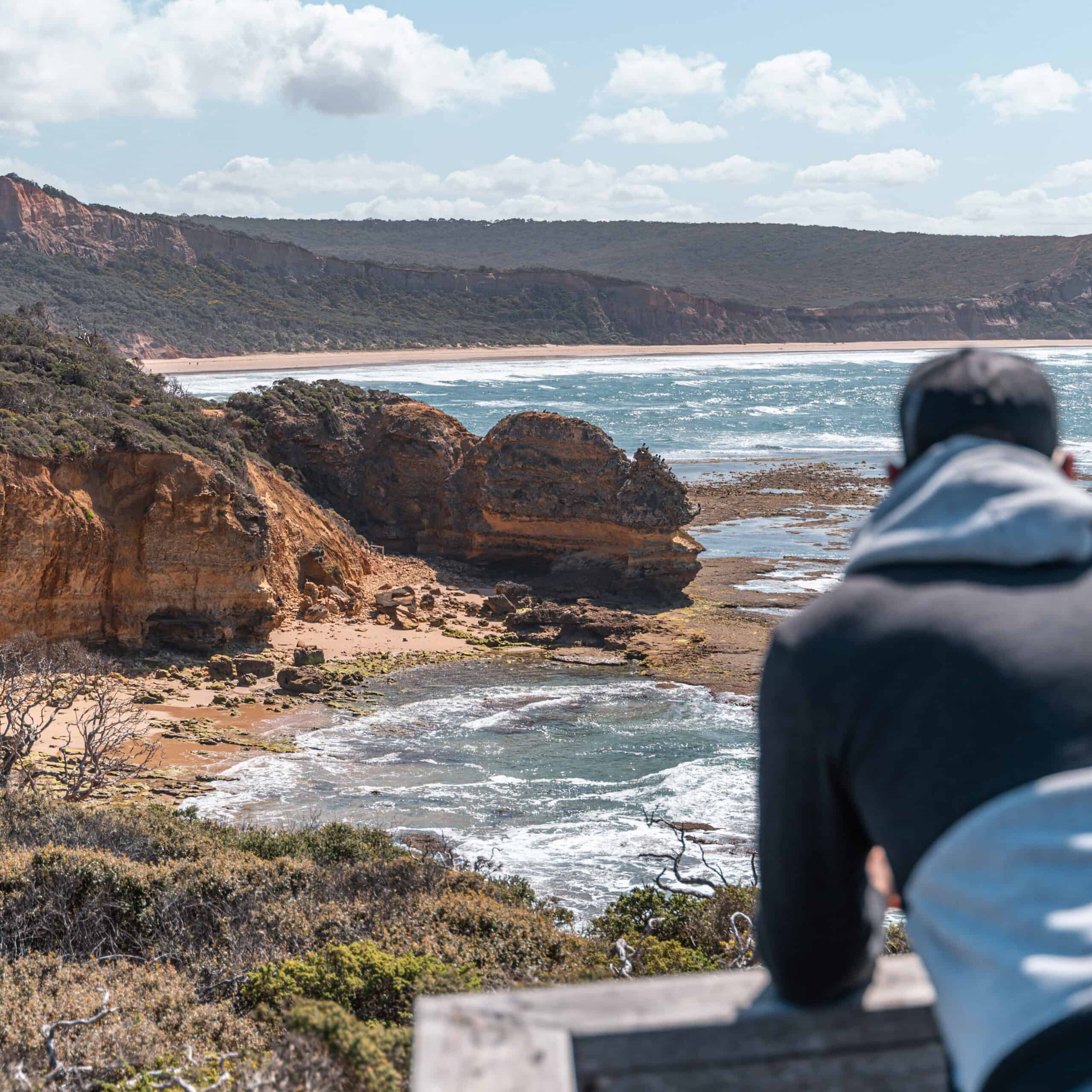 Wade admiring the views at Point Addis Lookout. He is leaning over a platform and checking the view of some incredible cliffs. 
