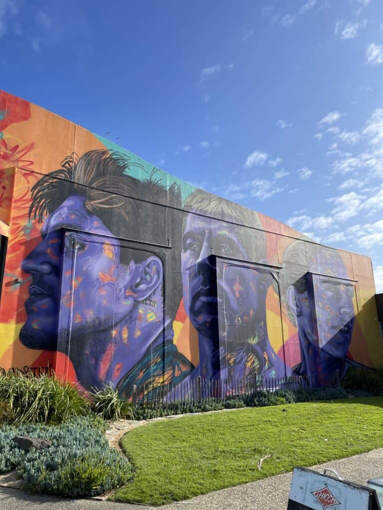 Rip Curl's store outside wall showing a painting of 3 surfers. 