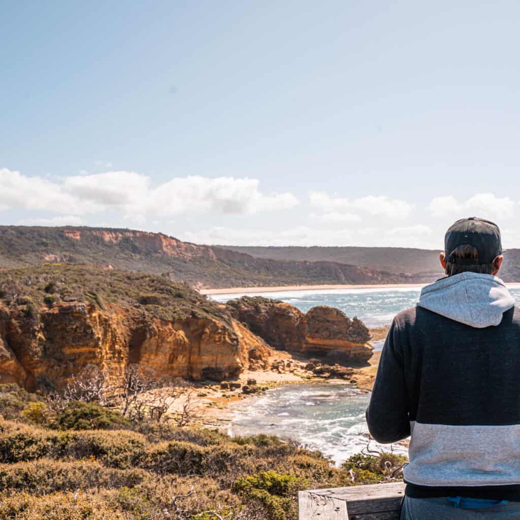 Wade standing on a wooden platform looking at the cliffs. 