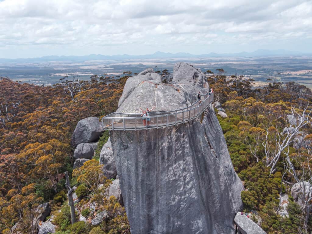 Wade and Dani standing at the top of Granite Skywalk with their arms open