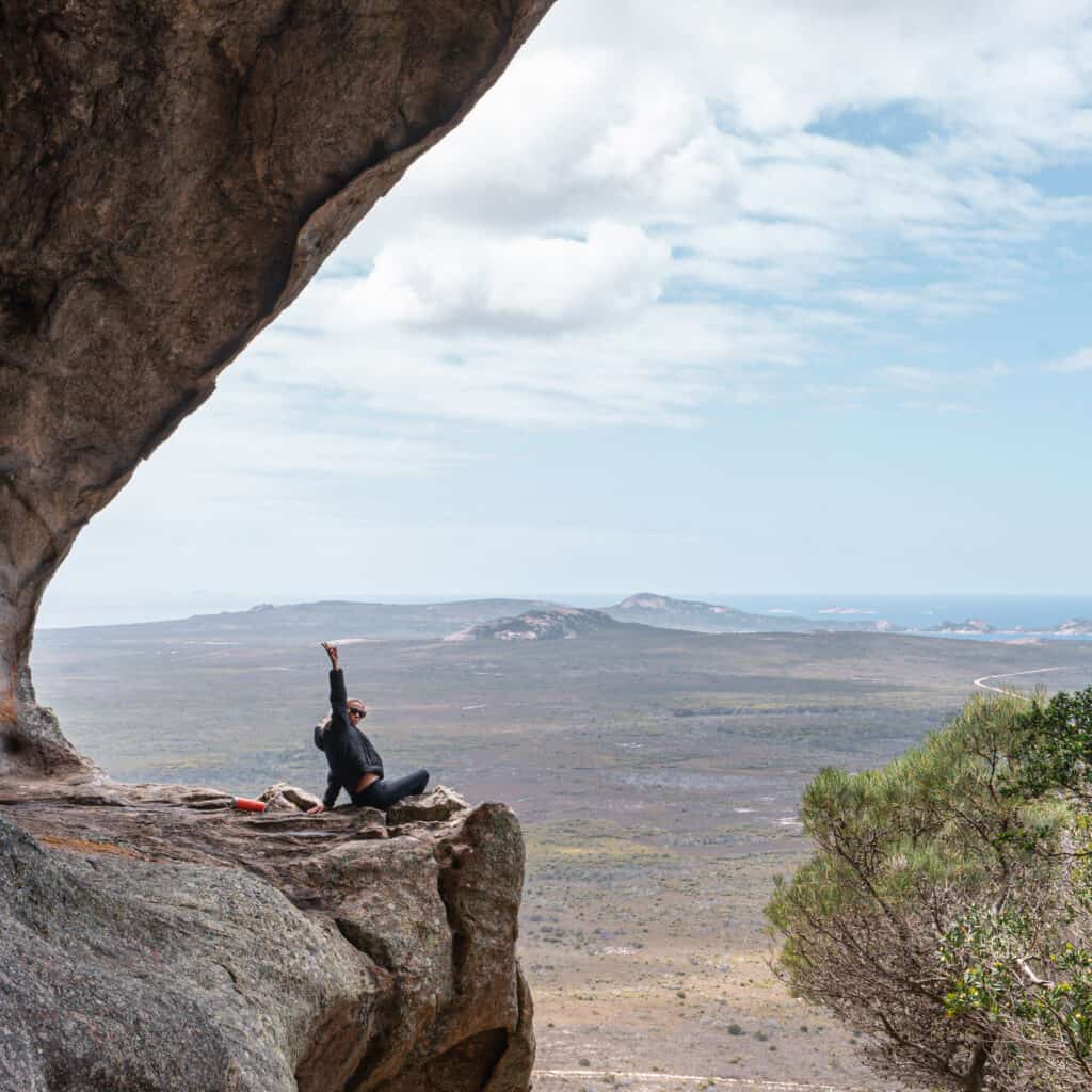 Dani sitting at the summit of Frenchman Peak where she can have an overall view of Cape Le Grand National Park