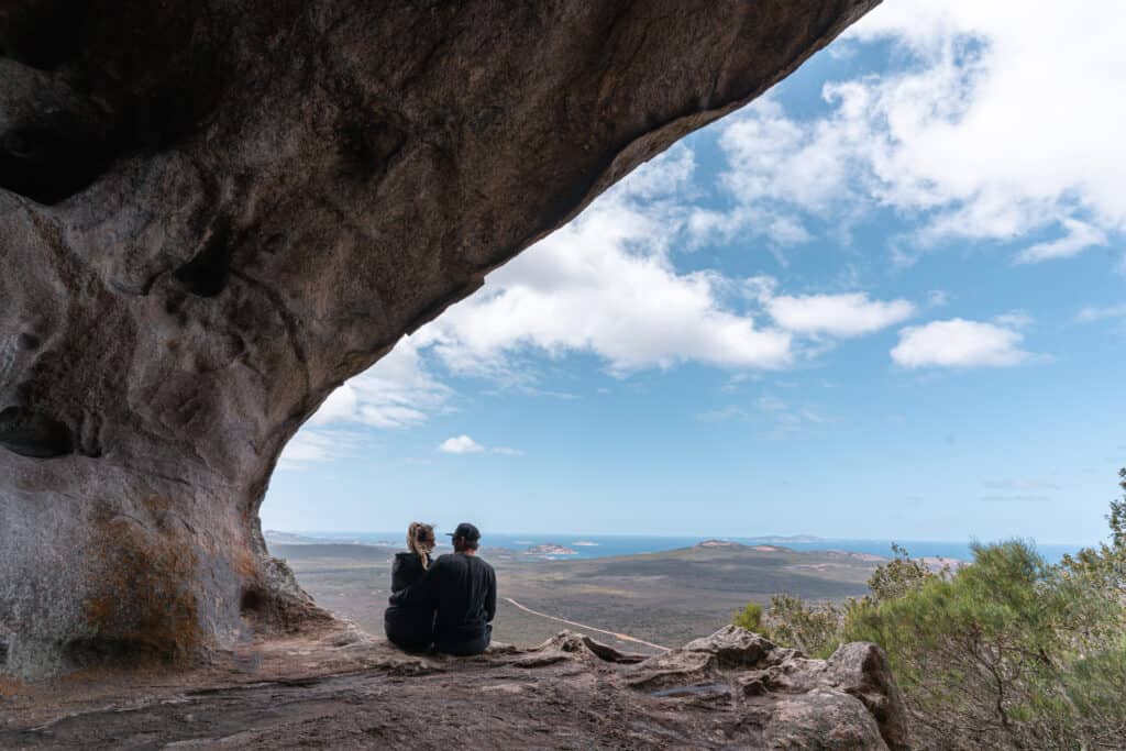 Wade and Dani sitting at the summit of Frenchman Peak where they can have an overall view of Cape Le Grand National Park