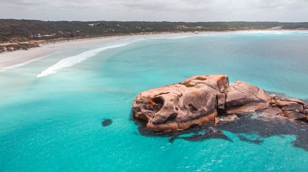 A giant rock in the middle of a turquoise blue ocean at Twilight Beach