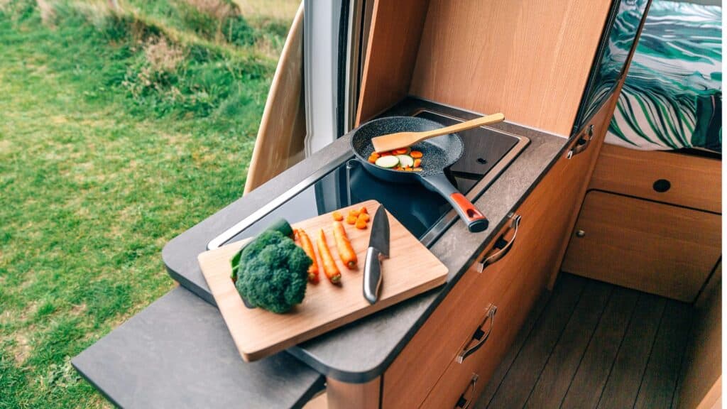 Chopping board with food and cooking on an induction cooktop