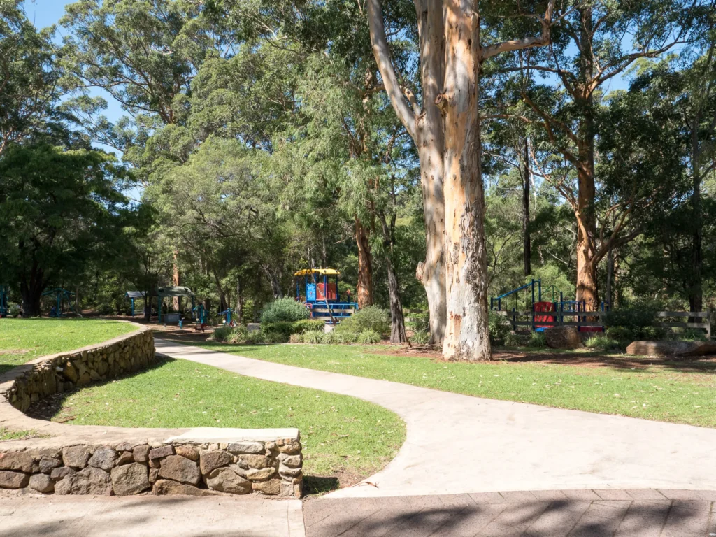 Picture of the Rotary Park in Margaret River, you can see grass, trees and little houses for kids to play