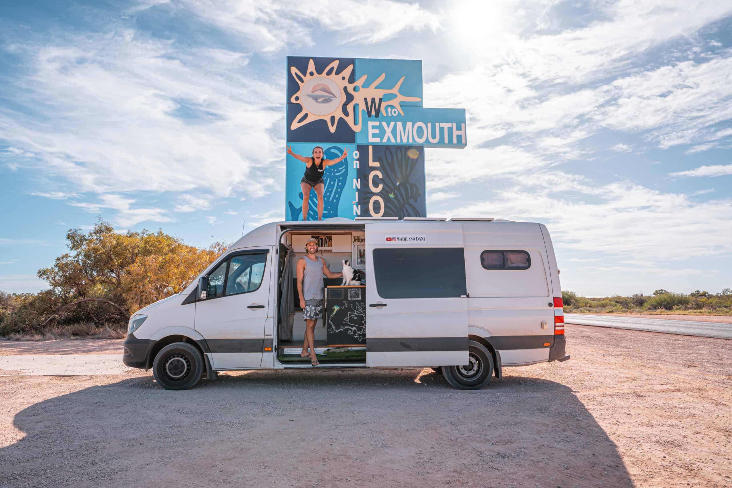 Camper van under the Exmouth sign and a couple inside the van