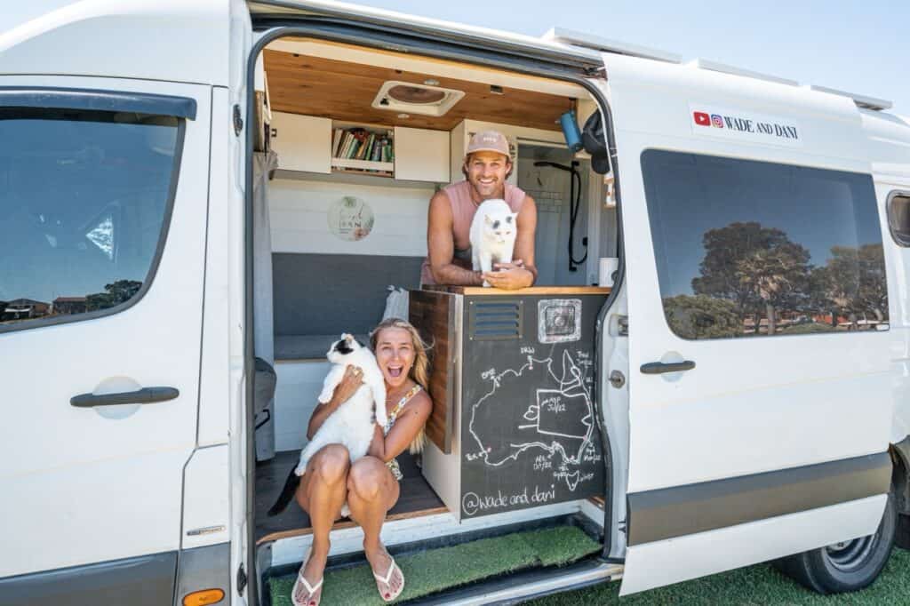 Wade and Dani inside their camper van with 2 cats